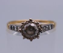 An 18 ct gold ring set with diamond chip shoulders. Ring size P. 2.4 grammes total weight.