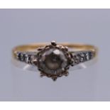 An 18 ct gold ring set with diamond chip shoulders. Ring size P. 2.4 grammes total weight.