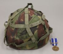 A British original Kosovo medal and combat helmet.