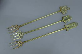 Three brass toasting forks with decorative tops, Ely Cathedral,