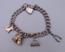 A silver charm bracelet with four charms. Approximately 17 cm long.