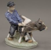 A Royal Copenhagen model of a boy and a calf. 16.5 cm high.