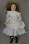 A 19th century bisque headed doll. 58 cm high.