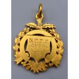 An unmarked gold medallion engraved BCSS Tug of War 1898. 3.5 cm high. 13.7 grammes.