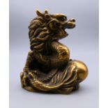 A bronze model of a Chinese dragon holding a ball/pearl. 8 cm high.