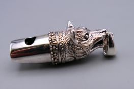 A silver whistle formed as a fox. 4 cm long.