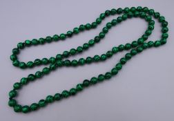 A string of malachite beads. Approximately 88 cm long.