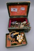 A quantity of costume jewellery in a green box.