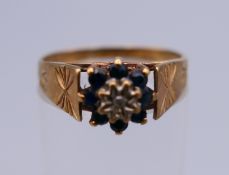 A 9 ct gold diamond and sapphire flowerhead ring. Ring size P. 2.4 grammes total weight.