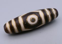 A gold inlaid dzi bead. 3.75 cm long.