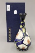 A boxed Moorcroft Chatsworth Orchid vase. 22.5 cm high.