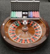 A full size casino roulette wheel with cased set chips. 81 cm diameter.