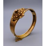 A Victorian unmarked 9 ct gold bangle form bracelet, boxed. 5.5 cm internal diameter. 14.9 grammes.