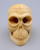 A carved bone model of a skull. 4 cm high.