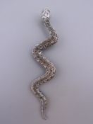 A silver snake pendant. 8.5 cm long.