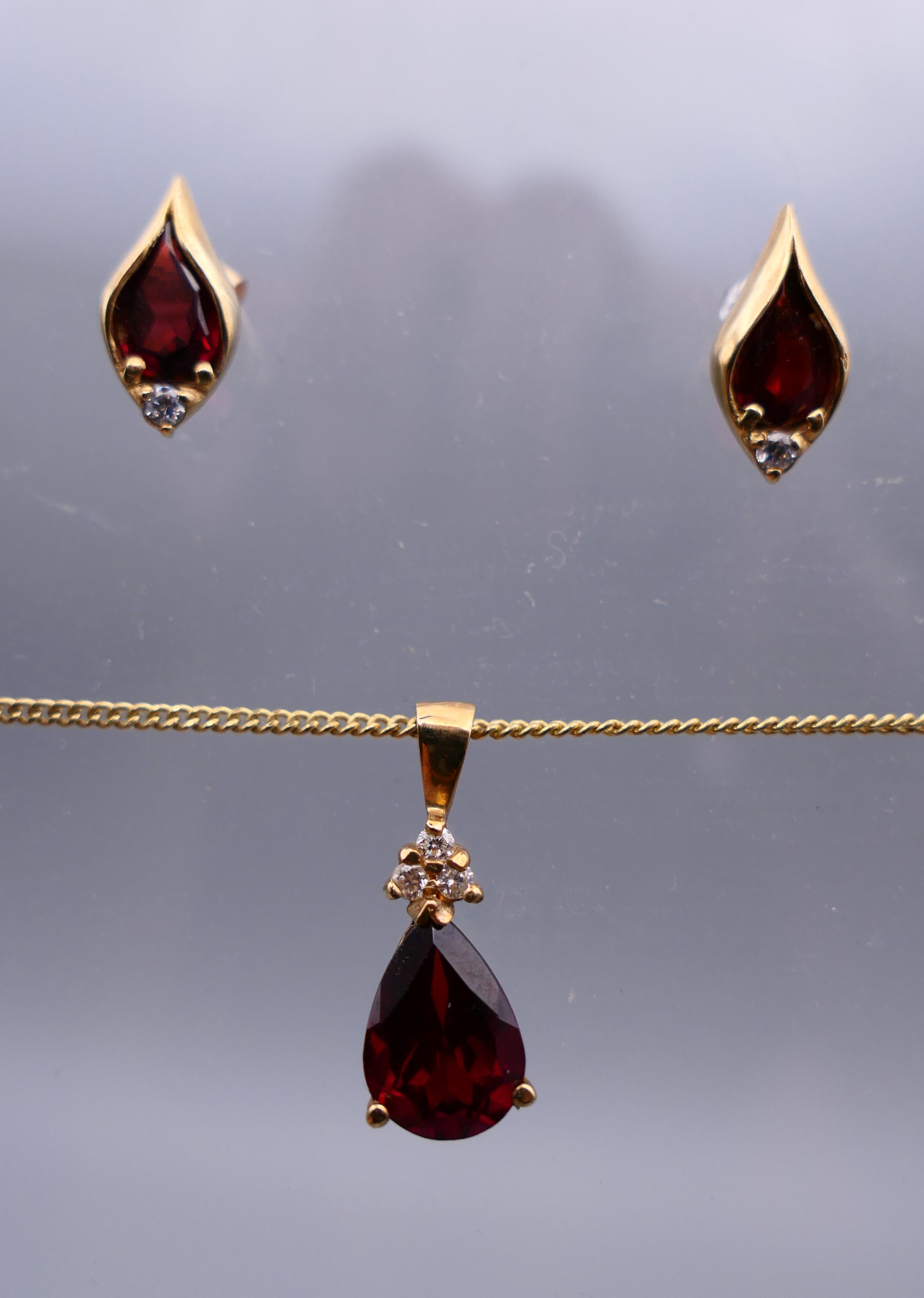 A 9 ct gold garnet pear drop pendant on a gold chain together with a pair of 9 ct gold earrings. - Image 3 of 6