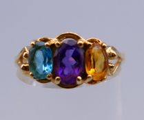 A 14 K gold multi-colour three stone ring. Ring size R/S. 3.3 grammes total weight.
