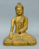 A carved and gilded seated Burmese Buddha with mirrored glass inlay. 35.5 cm high.