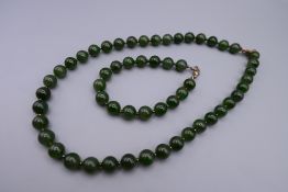 A string of green beads and a matching bracelet. Necklace 46 cm long, bracelet 20 cm long.