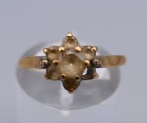A 9 ct gold flowerhead ring. Ring size O. 1.5 grammes total weight.