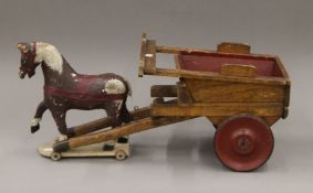 A vintage child's wooden pull along horse and a cart. The horse 29.5 cm high.