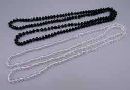 Two dress necklaces. Clear necklace 116 cm long, black necklace 114 cm long.