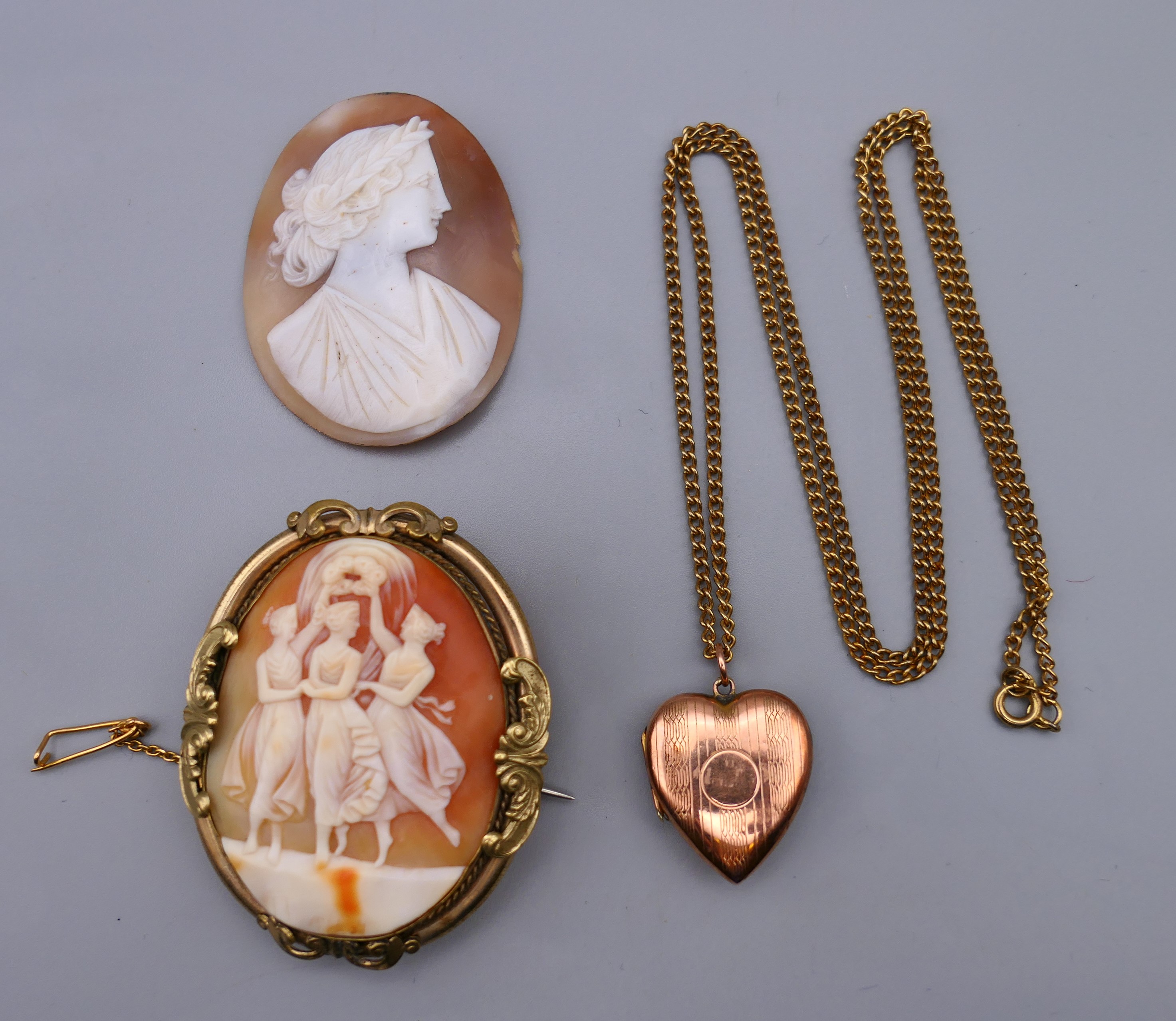 A cameo brooch, an unmounted cameo and a 9 ct gold back and front heart shaped locket on chain.