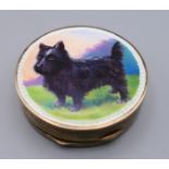A silver and enamel compact depicting a dog. 5 cm diameter.