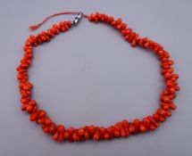 A coral necklace with silver clasp (part of clasp lacking). 38 cm long.