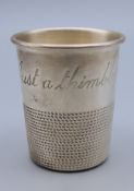 A shot cup formed as a large thimble engraved 'Just a thimbleful'. 5 cm high.