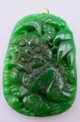 A gold mounted jade dragon pendant. 6.25 cm high.