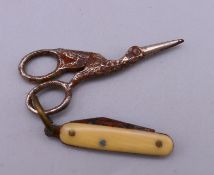 A miniature penknife and a pair of miniature sewing scissors. Penknife 2.5 cm long.