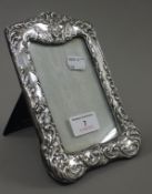 A silver photograph frame embossed with a cherub mask. 19 cm high.