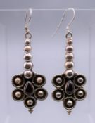 A pair of silver garnet drop earrings. 5 cm high.