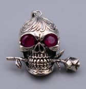 A skull form pendant. 3.5 cm wide.