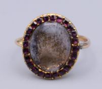 An 18th century unmarked gold mourning ring with oval central setting surrounded with amethysts,