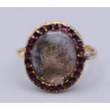 An 18th century unmarked gold mourning ring with oval central setting surrounded with amethysts,