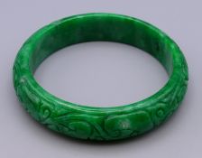 A carved jade bangle. 5.75 cm internal diameter.
