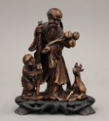 A Chinese carved soapstone group mounted on a carved wooden plinth base. 15 cm high overall.