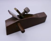 A small bronze model of a wood plane. 8.5 cm long.