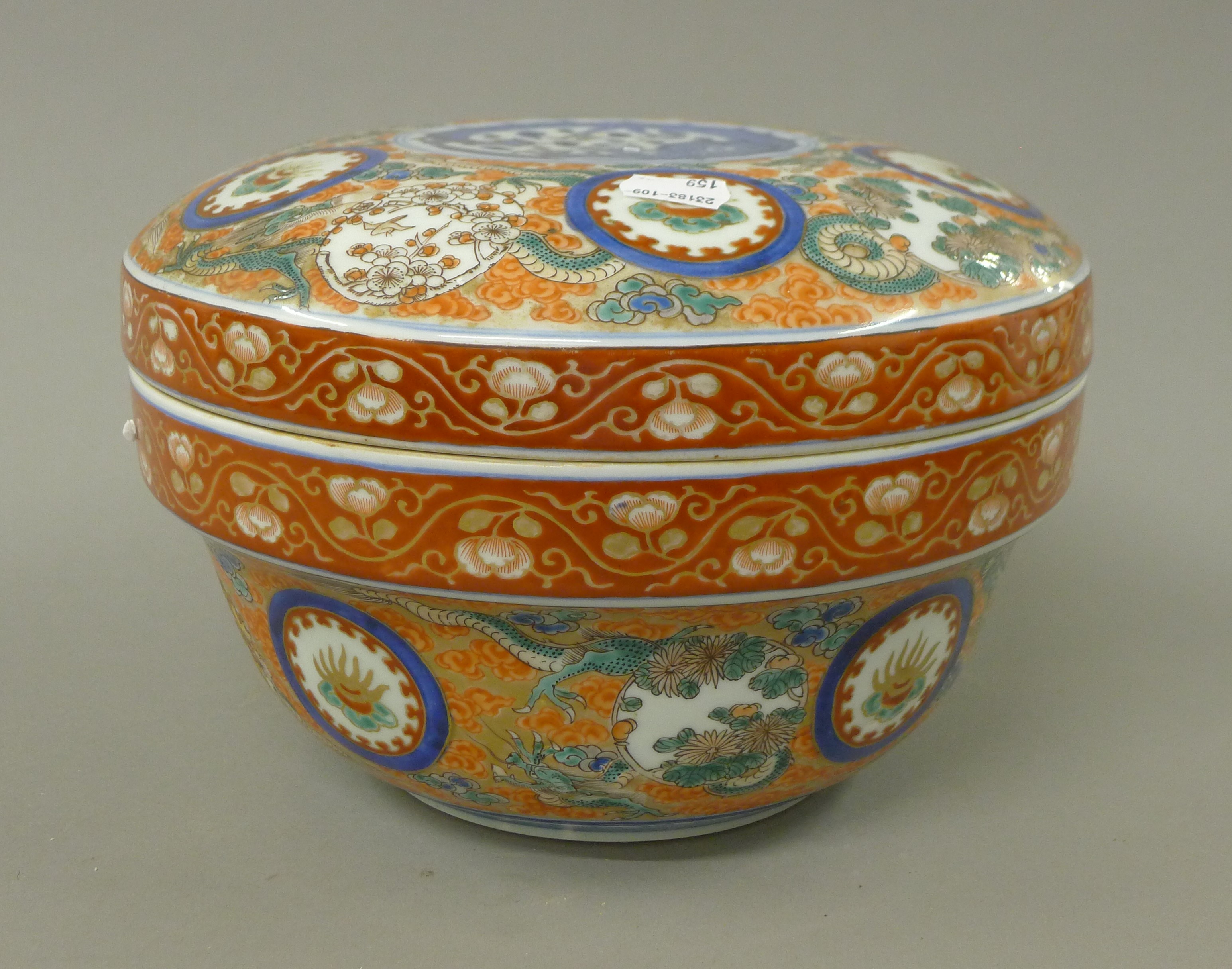 A Chinese porcelain orange lidded tureen decorated with dragons. 18 cm high.