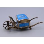 An unmarked silver and enamel stamp box formed as a cart. 8 cm long, 3 cm wide.