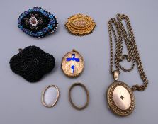 A locket on chain, another locket, two beaded brooches and another brooch.
