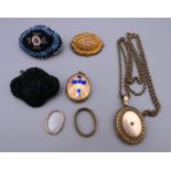 A locket on chain, another locket, two beaded brooches and another brooch.