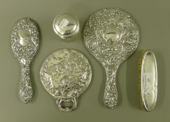 Three silver dressing table mirrors, a dressing table brush and a silver lidded pot.