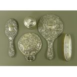 Three silver dressing table mirrors, a dressing table brush and a silver lidded pot.