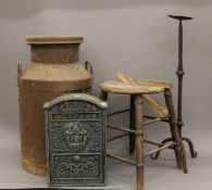 A vintage milk churn, a stool, an iron candle stand and a post box.