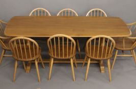 A blonde Ercol dining suite, comprising table, set of eight chairs and a sideboard.