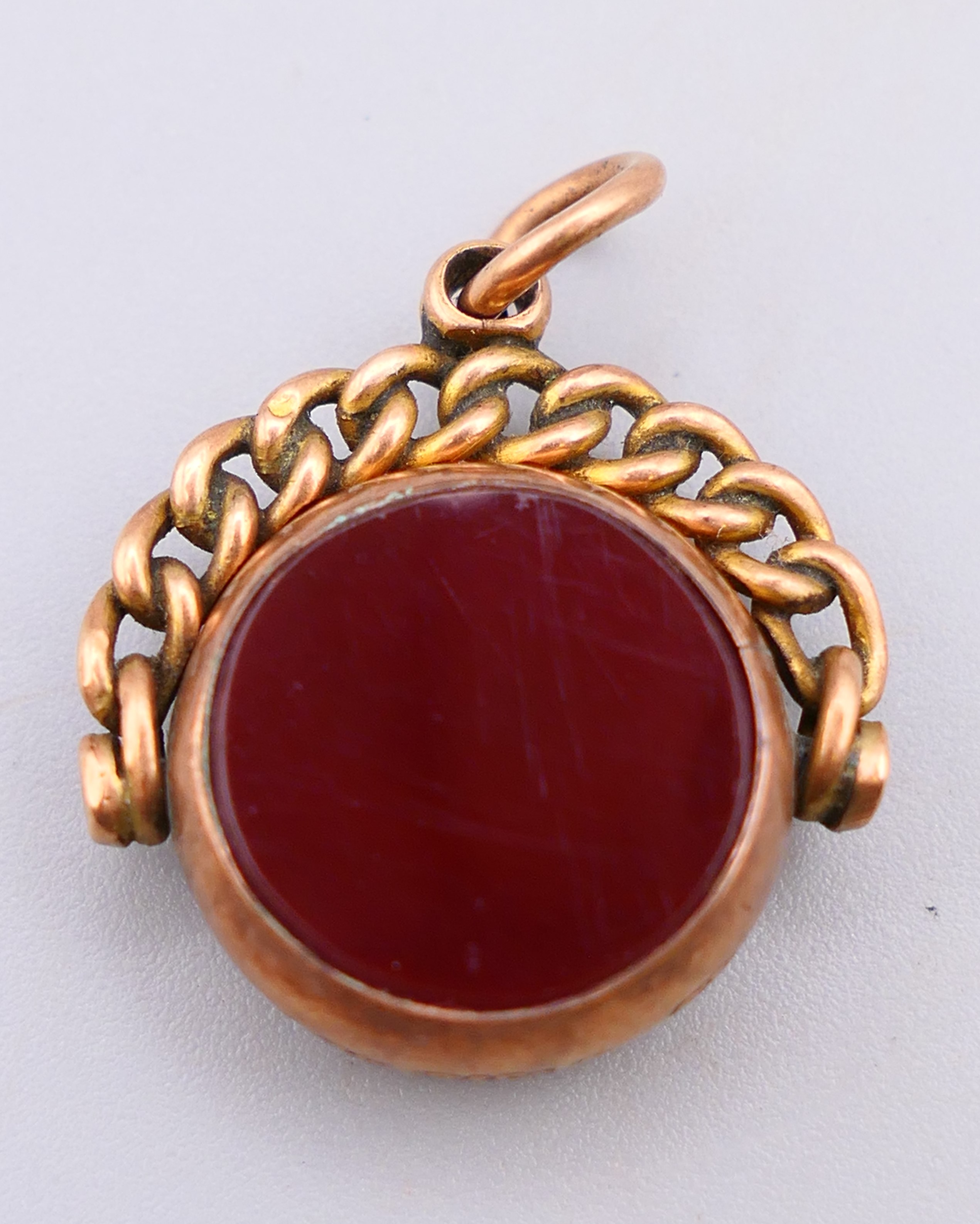 A 9 ct gold bloodstone and agate swivel fob pendant. 2 cm wide. 3.8 grammes total weight.