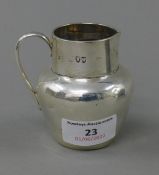 A Mappin and Webb silver cream jug. 7 cm high. 100 grammes.